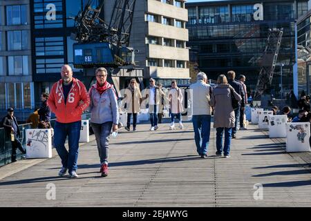 Düsseldorf, NRW, 2021. Les gens apprécient leur dimanche après-midi dans un beau soleil chaud avec des températures allant jusqu'à 18 degrés dans le quartier populaire de MedienHafen (port de médias), un quartier réaménagé par le Rhin accueillant des entreprises de médias, des bureaux, des divertissements, des restaurants et des installations de loisirs à Düsseldorf, la capitale de l'État le plus peuplé d'Allemagne de Rhénanie-du Nord-Westphalie. Credit: Imagetraceur/Alamy Live News Banque D'Images