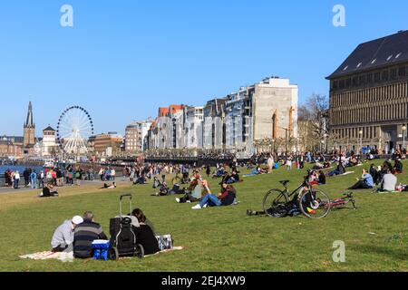Düsseldorf, NRW, 2021. Les gens apprécient leur dimanche après-midi dans un beau soleil chaud avec des températures allant jusqu'à 18 degrés, se baladant le long du Rhin et se détendant sur la pelouse de Düsseldorf, la capitale de l'État le plus peuplé d'Allemagne, la Rhénanie-du-Nord-Westphalie. Credit: Imagetraceur/Alamy Live News Banque D'Images