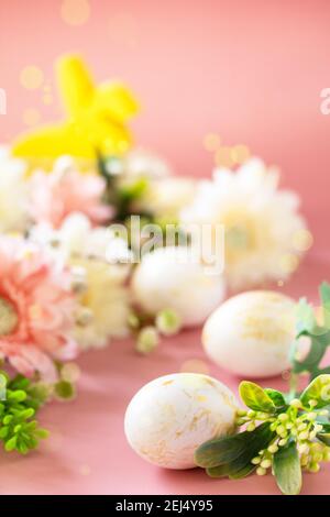 Fond floral de Pâques. Fleurs de printemps gerbera avec des oeufs de pâques sur fond rose. Copier l'espace. Banque D'Images