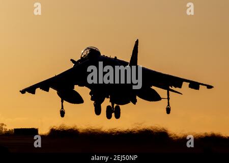 La silhouette d'un bombardier de chasseurs Harrier débarque au coucher du soleil avec un ciel orange Banque D'Images