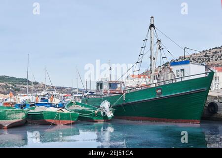 un vieux petit bateau de pêche et plusieurs bateaux sont amarrés le port Banque D'Images