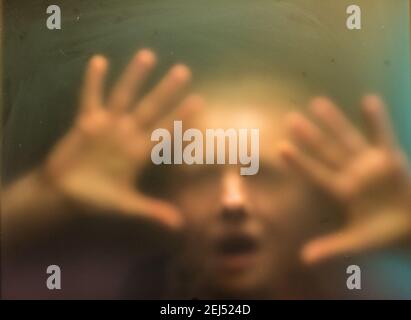 Tableau effrayant des mains derrière le verre Banque D'Images