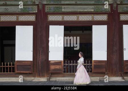 Femme asiatique portant une robe de hanbok traditionnelle rose au palais de Changdeokgung, Séoul, Corée du Sud Banque D'Images