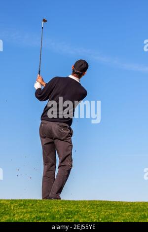 Golfeur en train de jouer au golf avec le club sur le parcours couleur vintage, Homme jouant au golf sur un parcours de golf au soleil, en été Banque D'Images