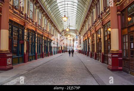 Un couple passe devant les magasins fermés du marché de Leadenhall pendant le confinement du coronavirus. Londres, Royaume-Uni février 2021. Banque D'Images