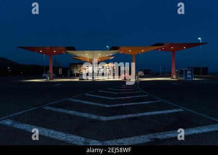 Station de service Repsol, avec les parapluies inversés d'origine pour couvrir les pistes, image de nuit. Banque D'Images