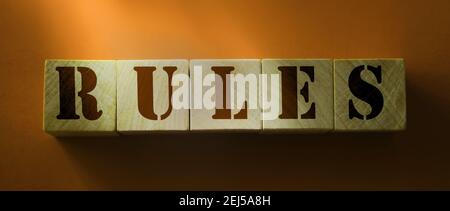 Règles sur cubes en bois sur fond rouge. Règles, politiques et procédures concept de droit Banque D'Images
