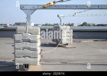 Contrepoids ou contrepoids blocs de béton ou briques en tant que partie de la plate-forme de corde de fil suspendu pour les travaux de façade sur de hauts bâtiments à plusieurs étages. Homme Banque D'Images