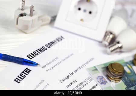 Calculatrice et euro avec stylo sur facture d'électricité européenne. Concept d'économie d'argent en utilisant des ampoules LED à économie d'énergie et le paiement de facture électrique Banque D'Images