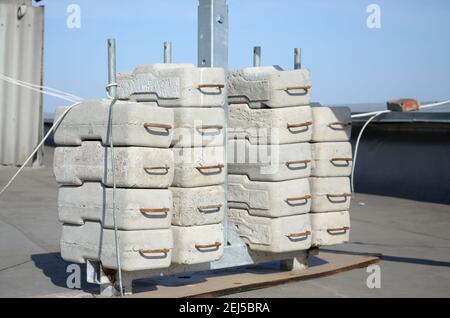 Contrepoids ou contrepoids blocs de béton ou briques en tant que partie de la plate-forme de corde de fil suspendu pour les travaux de façade sur de hauts bâtiments à plusieurs étages. Homme Banque D'Images