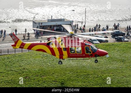 Essex & Herts Air Ambulance décollage de Cliff Gardens à Southend on Sea, Essex, Royaume-Uni, un jour d'hiver, pendant le confinement de la COVID 19. Les gens regardent Banque D'Images