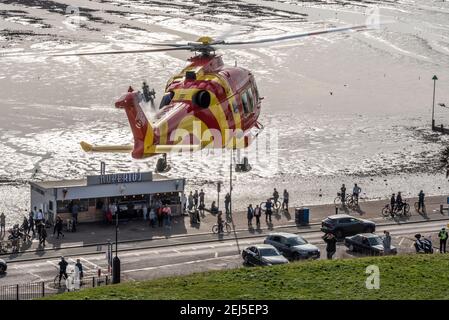 L'hélicoptère Essex & Herts Air Ambulance décolle de Cliffs à Southend on Sea, Essex, Royaume-Uni, lors d'une journée chargée pendant le confinement de la COVID 19. Les gens regardent Banque D'Images