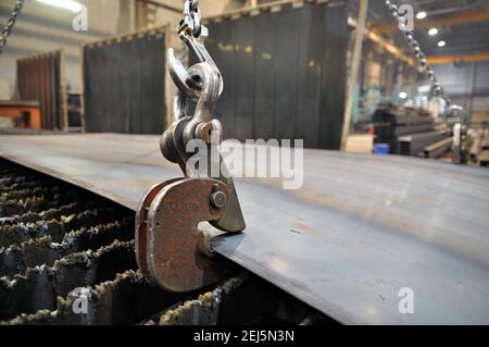 Chaînes et crochets de levage pour le chargement de la tôle. Placer du métal sur une machine à découper le plasma. Banque D'Images