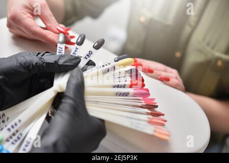 La femme choisit la couleur du vernis à ongles au salon de manucure Banque D'Images