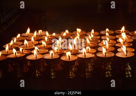 Un cliché sélectif de bougies allumées disposées en rangées dans Le festival indien du temple Banque D'Images