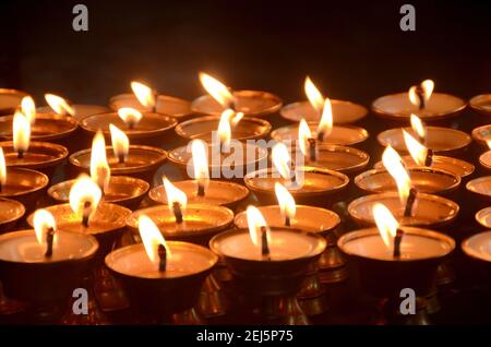 Un cliché sélectif de bougies allumées disposées en rangées dans Le festival indien du temple Banque D'Images