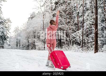 Fille vote dans les bois par une voiture cassée.Forêt d'hiver, le gel et la neige Banque D'Images