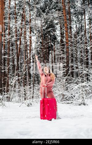 Fille vote dans les bois par une voiture cassée.Forêt d'hiver, le gel et la neige Banque D'Images