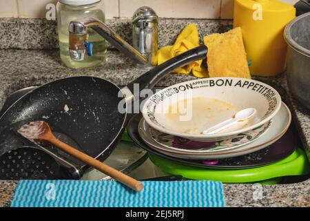 Vaisselle sale, couverts et casseroles dans l'évier prêts à être lavés. Banque D'Images