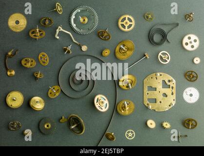 Pièces de rechange pour horloge. Engrenage en métal, roues dentées et autres détails. Sur fond gris Banque D'Images