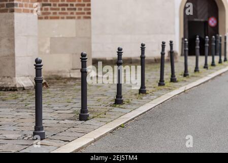 Poteaux de parking. Les vieilles poteaux noirs sur le trottoir limitent l'espace. Banque D'Images