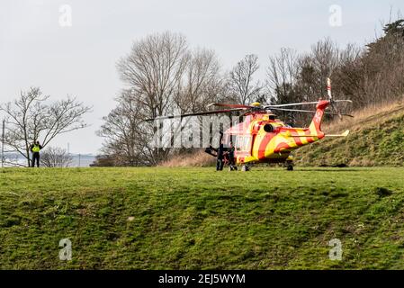 Essex & Herts Air Ambulance a atterri sur les falaises de Southend sur la mer, Essex, Royaume-Uni, lors d'une journée ensoleillée. Équipage en attente en hélicoptère. Officier de patrouille civile Banque D'Images