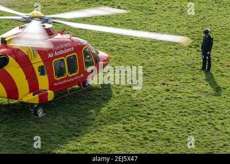 Essex & Herts Air Ambulance sur l'herbe à Southend sur la mer, Essex, Royaume-Uni, lors d'une belle journée d'hiver ensoleillée. Surveillance de l'équipage de conduite à l'extérieur pendant le démarrage Banque D'Images