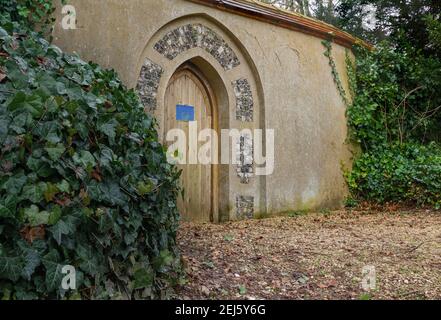 porte en bois de la cathédrale dans un mur de pierre en forme de menteur au jardin de vicarage Banque D'Images