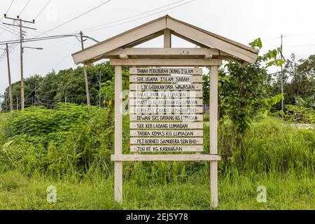 Panneau, présentant une liste de magasins et d'organisations dans le village de Lumadan à Sabah, en Malaisie, situé à la porte du village. Banque D'Images