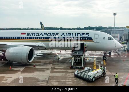 Un chargeur ULD soulevant un dispositif de charge unitaire (ULD) de Un tablier s'étend jusqu'à une baie de fret d'avions d'un Singapour Compagnie aérienne à l'aéroport Changi de Singapour