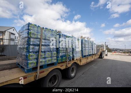 Oak Hill, TX USA 21 février 2021 : des cas d'eau embouteillée arrivent par camion à l'ouest désespéré du comté de Travis, TX résidents hors de l'eau du robinet pendant plusieurs jours en raison de la tempête de neige dévastatrice du Texas la semaine dernière. Les conducteurs n'ont été autorisés qu'un seul cas par voiture après que certains aient attendu trois heures en file d'attente. Crédit : Bob Daemmrich/Alay Live News Banque D'Images