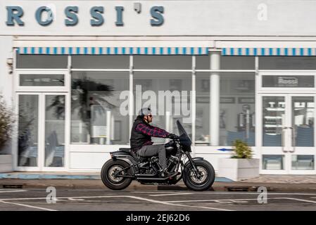 Harley Davidson moto passant devant le glacier de Rossi à Southend sur la mer, Essex, Royaume-Uni, lors d'une journée d'hiver ensoleillée, pendant le confinement de la COVID 19 Banque D'Images