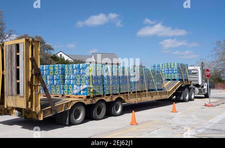 Oak Hill, TX USA 21 février 2021 : des cas d'eau embouteillée arrivent par camion à l'ouest désespéré du comté de Travis, TX résidents hors de l'eau du robinet pendant plusieurs jours en raison de la tempête de neige dévastatrice du Texas la semaine dernière. Les conducteurs n'ont été autorisés qu'un seul cas par voiture après que certains aient attendu trois heures en file d'attente. Crédit : Bob Daemmrich/Alay Live News Banque D'Images