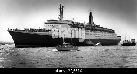 AJAXNETPHOTO. (SOU) SOUTHAMPTON, ANGLETERRE. 12 MAI 1982.- DÉPART D'UN BATEAU - LE PAQUEBOT CUNARD QE2 LAISSE 38 BERTH, ESCORTÉ PAR DES REMORQUEURS ET UNE FLOTTILLE DE PETITS BATEAUX SUR LA PREMIÈRE ÉTAPE DE SON VOYAGE AUX ÎLES FALKLAND. LE PAQUEBOT DE 67,000 TONNES A ÉTÉ CONVERTI EN UNE SEMAINE ET ÉQUIPÉ DE TROIS PATINS D'HÉLICOPTÈRE. LE QE2 EMBARQUE 3,500 SOLDATS DES GARDES GALLOIS ET ÉCOSSAIS ET DE LA BRIGADE DE GHURKAS POUR LE LONG VOYAGE DANS L'ATLANTIQUE SUD. PHOTO: JONATHAN EASTLAND/AJAX REF: 909598 CD211031 13 Banque D'Images