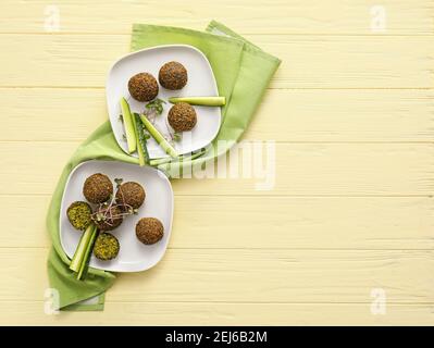 Assiettes avec de savoureuses boulettes de falafel et concombre sur du bois de couleur arrière-plan Banque D'Images