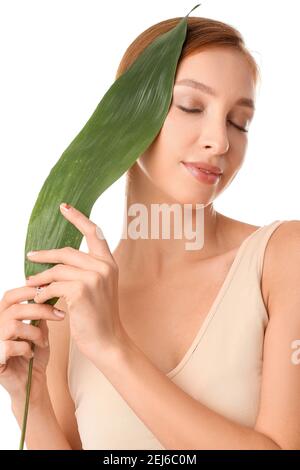 Belle jeune femme avec des feuilles tropicales sur fond blanc Banque D'Images