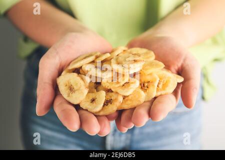 Femme tenant des chips de banane, gros plan Banque D'Images