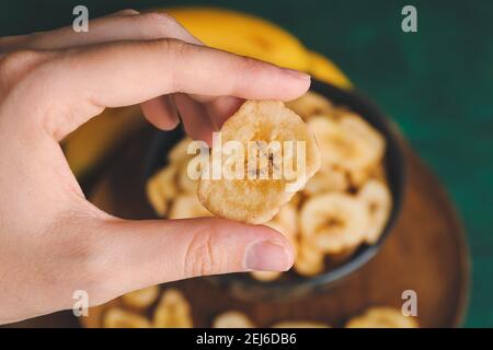 Femme tenant des chips de banane, gros plan Banque D'Images