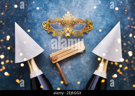 Fête juive célébration Purim fond avec chapeaux de fête, masque et champagne sur fond bleu. Vue de dessus Banque D'Images