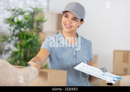 bonne femme de livraison en train de secouer la main du client Banque D'Images