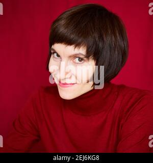 Femme brunette mûre souriante à l'aspect ludique et combatif, portrait en gros plan d'une femme d'âge moyen Banque D'Images