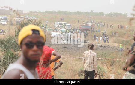 Abuja, Nigéria. 21 février 2021. Des spectateurs et des sauveteurs sont vus sur les lieux d'un accident d'avion militaire à Abuja, au Nigeria, le 21 février 2021. Sept personnes ont été tuées après l'accident d'un avion militaire à Abuja, la capitale du Nigeria dimanche, a déclaré un porte-parole de l'armée de l'air. Credit: Robert Oba/Xinhua/Alay Live News Banque D'Images