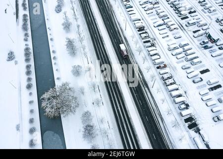 vue aérienne du grand parking avec de nombreuses voitures enneigées en hiver. photo de drone d'en haut Banque D'Images