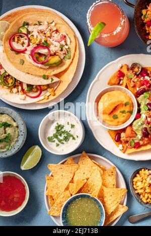 Cuisine mexicaine sur fond bleu. Nachos, tacos et trempettes, cocktails, dose de vue Banque D'Images