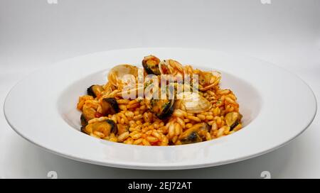 Délicieux risotto aux fruits de mer, risotto ai frutti di mare, sur un plat blanc. Banque D'Images