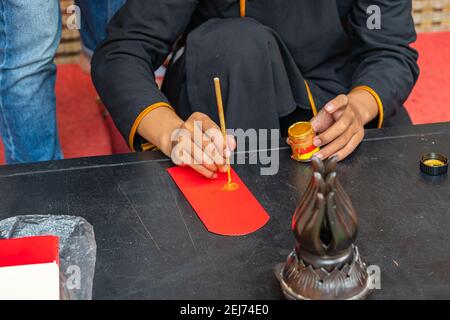 Les gens qui font l'écriture avec la calligraphie traditionnelle brosse stylo sur le chinois enveloppe de l'argent chanceux Banque D'Images