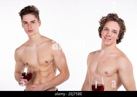 Jours fériés et week-ends. Jeune couple attrayant qui boit du vin rouge. Arrière-plan blanc. Banque D'Images