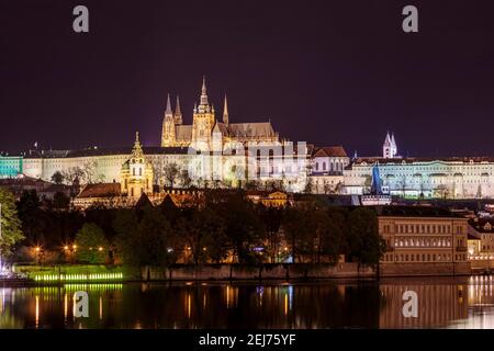 Pont Charles à Prague dans la soirée avec lumières colorées de lanternes. Dans la rivière le reflet des illuminations du soir. Banque D'Images