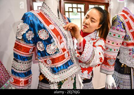 (210222) -- QIANXI, le 22 février 2021 (Xinhua) -- Yang Wenli, du groupe ethnique Miao, organise des costumes Miao au site de réinstallation des populations pauvres dans le village de Huawu, comté de Qianxi de Bijie, province de Guizhou, dans le sud-ouest de la Chine, le 20 février 2021. Situé dans la région montagneuse profonde du canton de Xinren Miao de Guizhou, le village de Huawu est célèbre pour ses paysages étonnants. Au cours des dernières années, avec les efforts du gouvernement local, le village développe la plantation, la culture et le tourisme tout en relocalisant les personnes touchées par la pauvreté. Aujourd'hui Huawu a pris un nouveau regard dans la nouvelle année, avec divers ind Banque D'Images