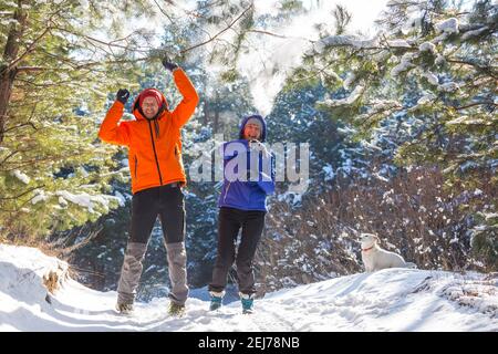 Jeune garçon et fille en vêtements d'hiver appréciant la neige dans le forêt Banque D'Images